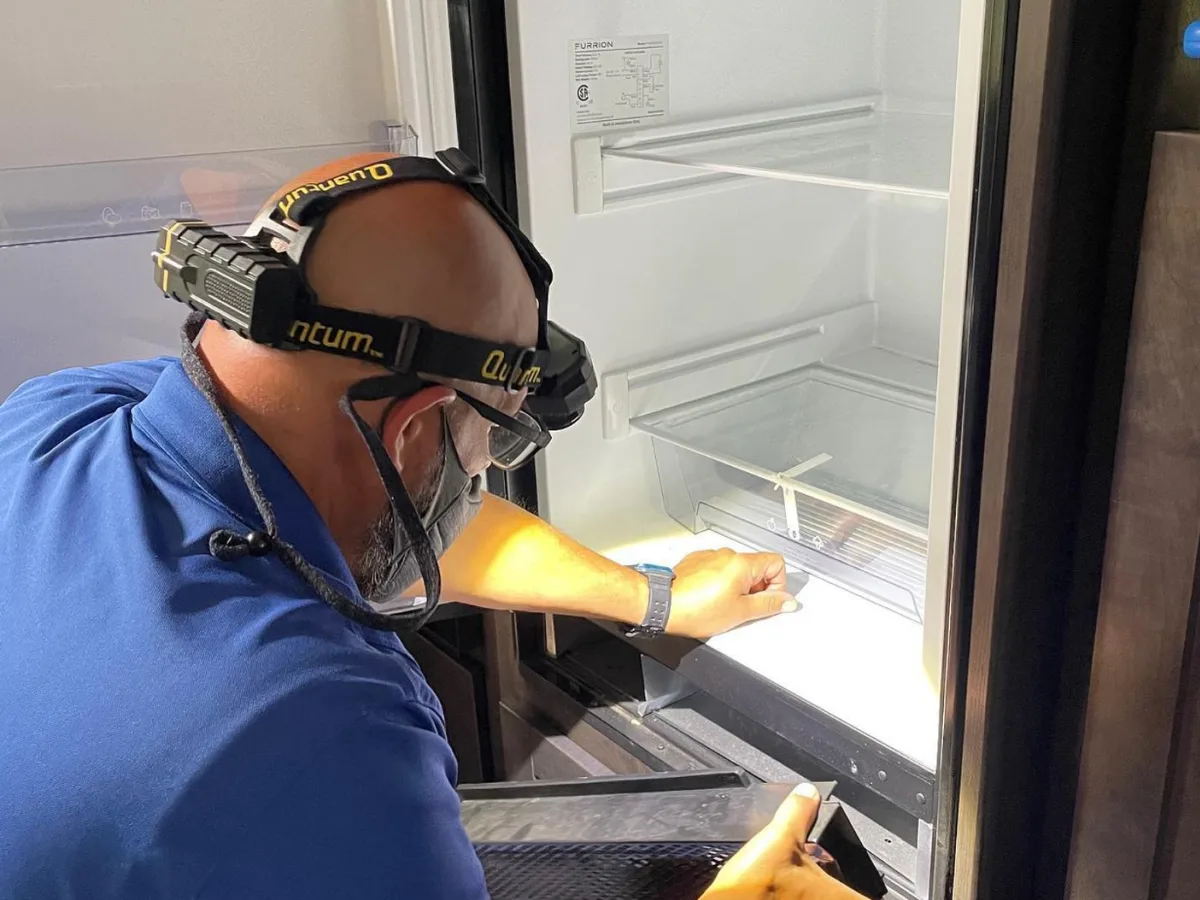 A technician diagnosing an RV refrigerator in Okeechobee, Florida